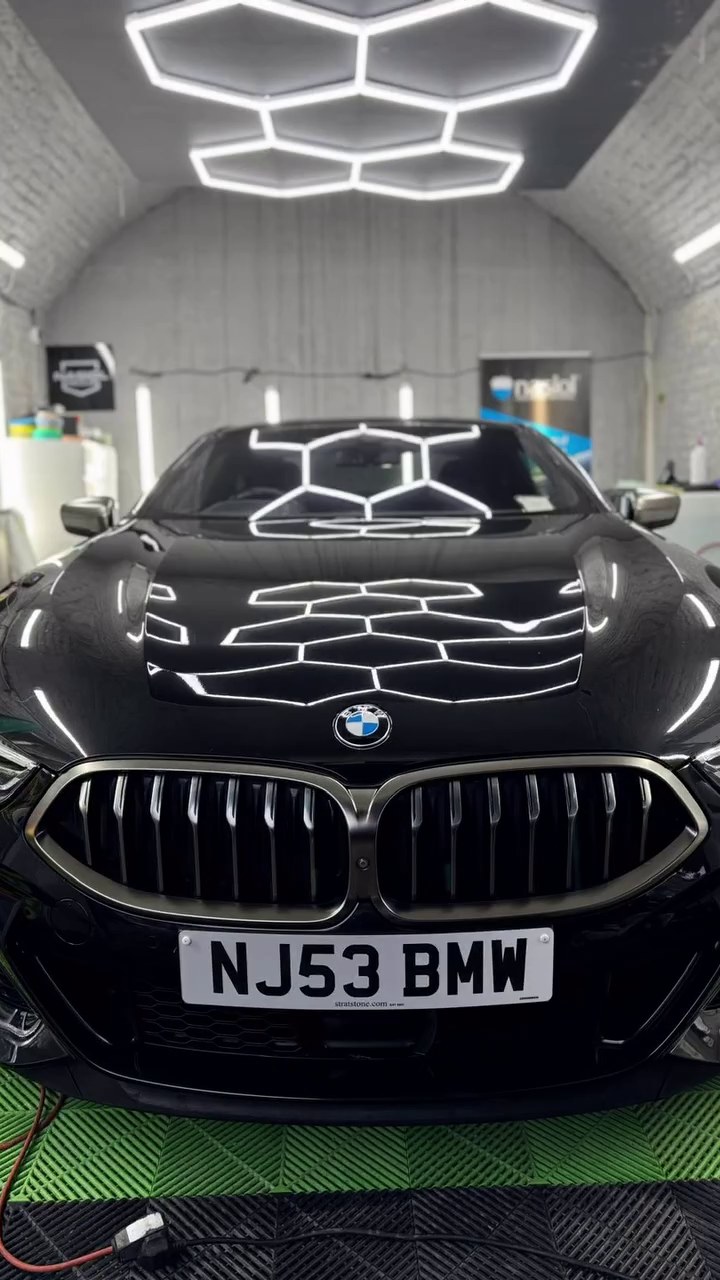 Ceramic-coated black BMW bonnet reflecting hexagonal studio lights